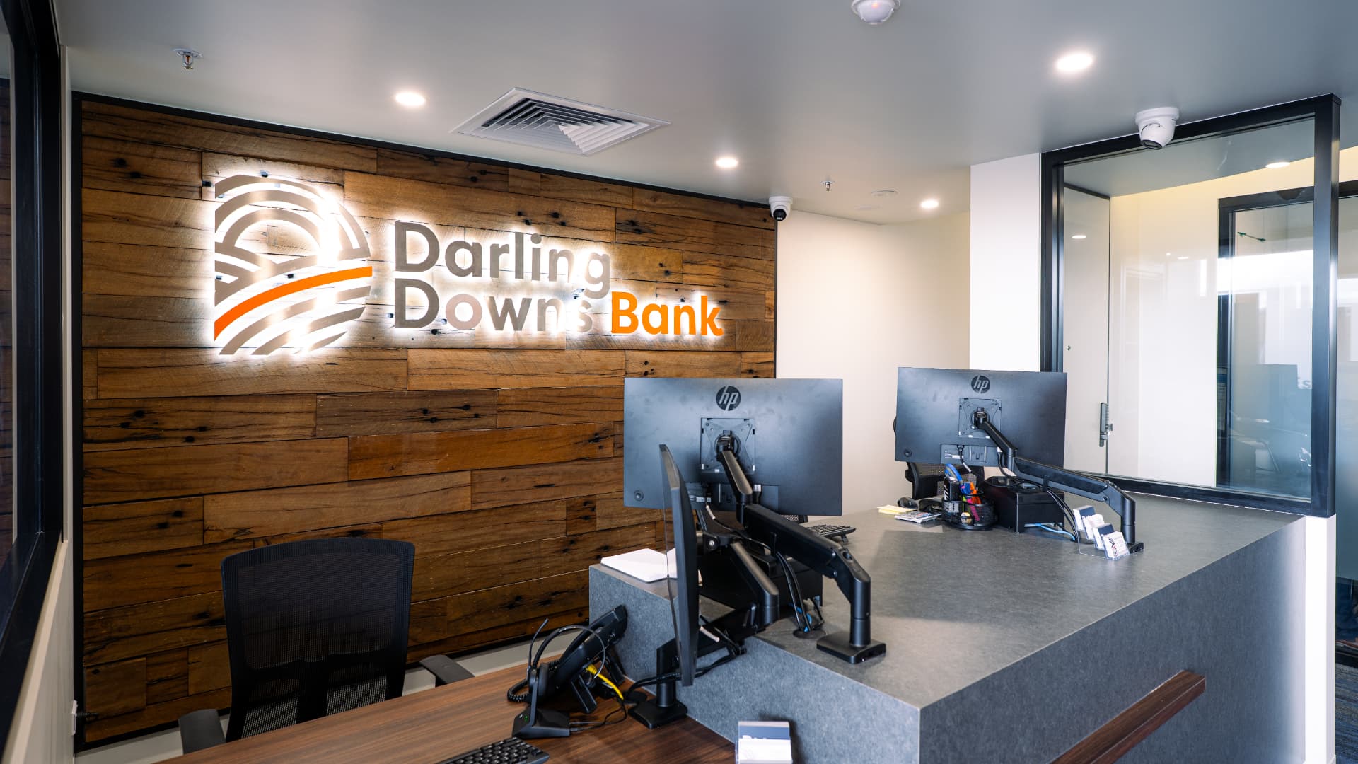 Completed reception counter with timber feature wall and illuminated business signage