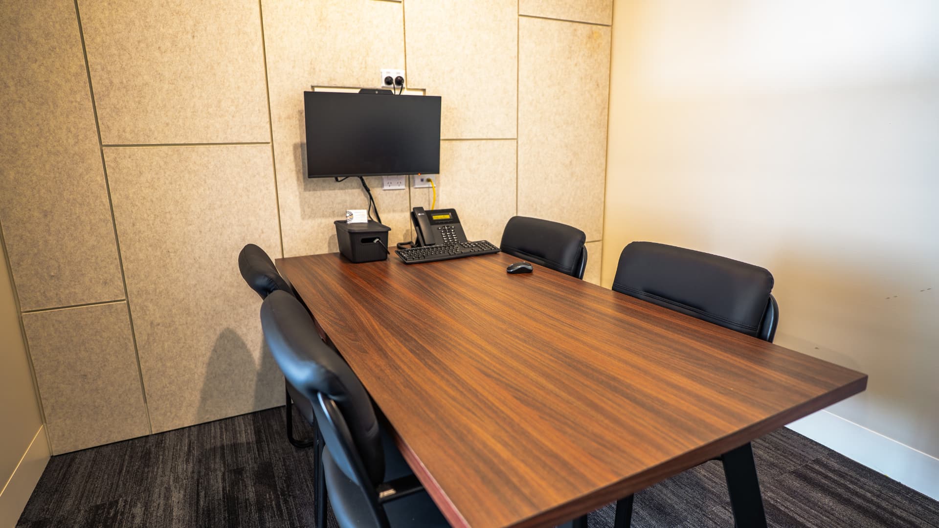 Completed meeting room with custom table and acoustic wall panels